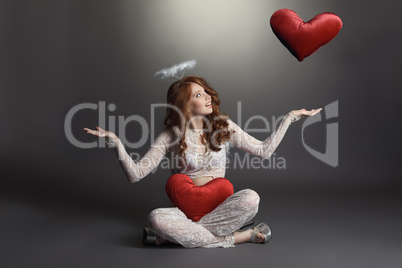 Studio shot of feminine angel playing with hearts