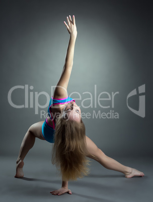View of graceful young woman training in studio