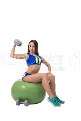 Slim brunette exercising with dumbbells in fitness