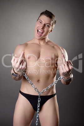 Seminude man in handcuffs showing obscene gestures