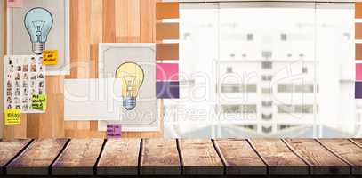 Composite image of light bulb charts attached on wooden wall