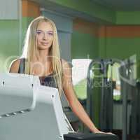 Gym. Attractive blonde exercising on treadmill