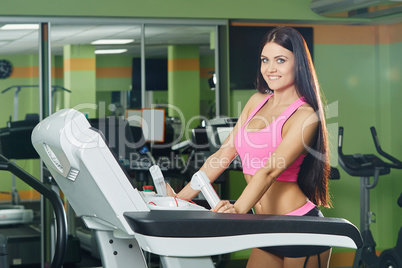 Gym. Sexy brunette exercising on treadmill