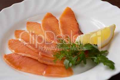 Restaurant food. Sliced salmon with lemon