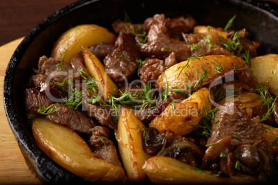 Potato wedges fried with meat and mushrooms