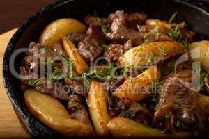 Potato wedges fried with meat and mushrooms