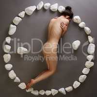 Yin-yang. Nude woman posing with stones