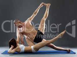 Paired yoga. Man and woman exercising in studio