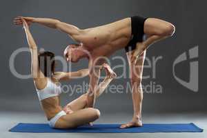 Paired yoga. Shot of instructors, on gray backdrop
