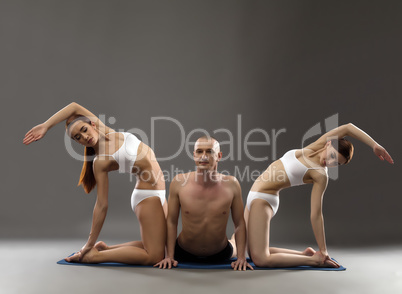 Image of man and girls practicing yoga threesome