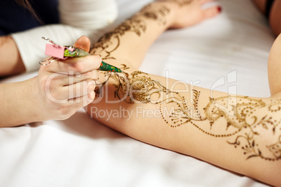 Mehndi. Master applying henna on model's hand