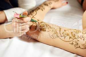 Mehndi. Master applying henna on model's hand