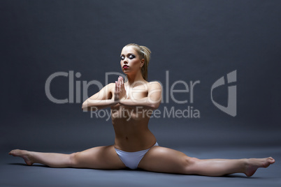 Sexy young topless woman doing stretching exercise