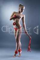 Studio photo of topless submissive girl with whip