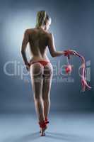 Image of nude girl with BDSM attributes. Back view