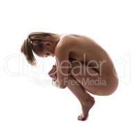 Nude young woman posing in pose of embryo