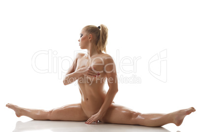 Stretching. Nude sweaty girl doing gymnastic split