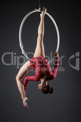 Sexy female acrobat exercising with hanging hoop
