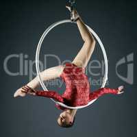 Lovely gymnast performs acrobatic stunt on hoop