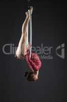 Image of gymnast performs hanging upside down