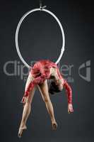 Beautiful aerialist doing acrobatic stunt on hoop