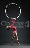 Studio shot of graceful acrobat performs with hoop