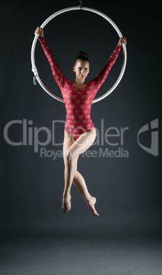 Young beautiful gymnast performs with hoop