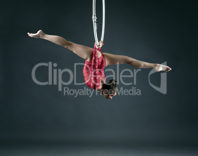 Flexible girl performs trick with hanging hoop