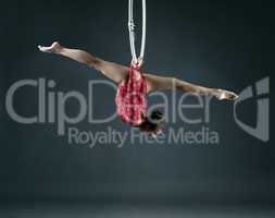 Flexible girl performs trick with hanging hoop