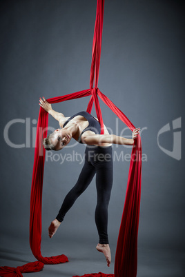 Attractive dancer posing with aerial silks