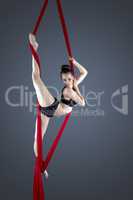 Flexible female gymnast performing aerial exercise