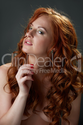 Curly red-haired beauty posing nude to waist