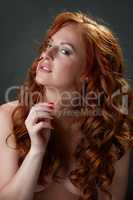 Curly red-haired beauty posing nude to waist