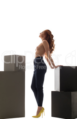 Studio shot of topless model posing with big cubes