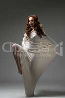 Modern dance. Red-haired woman posing with cloth