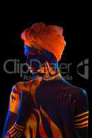 Portrait of topless woman with body art and turban