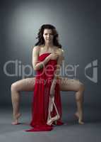 Attractive ballet dancer posing with red cloth