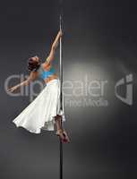 Image of dreamy woman dancing on pole in studio