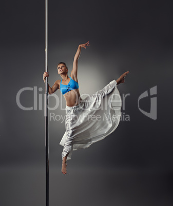 Strong and graceful girl dancing on pylon