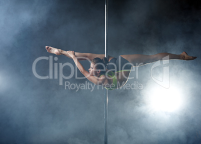 Flexible girl posing in difficult position on pole