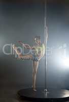 Graceful pole dancer in rays of spotlights