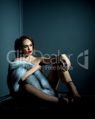 Studio photo of naked girl with expensive fur coat