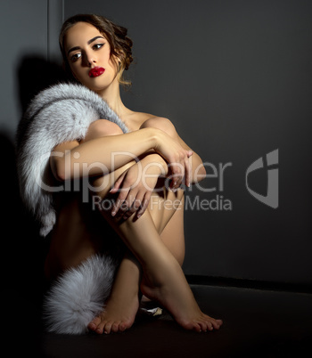 Sexual naked woman posing in chic fur coat