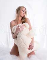 Image of sensual nude woman hugging teddy bear