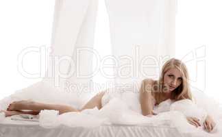 Erotica. Studio image of seductive blonde in bed