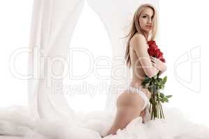 Beautiful blonde posing topless with rose bouquet