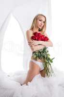 Nice topless blonde covers her breasts with roses