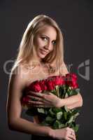 Smiling topless blonde with bouquet of roses