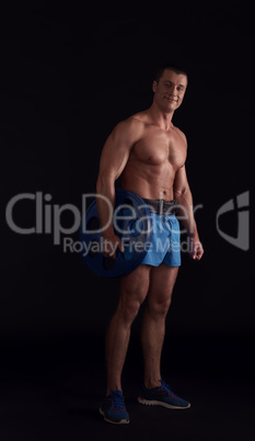 Handsome bodybuilder posing with barbell disk