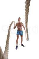 Smiling bodybuilder exercising with rope